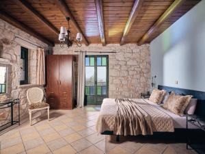 a bedroom with a bed and a stone wall at Diamond Suites in Vasilikos +136 photos