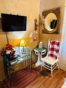a living room with a tv and a table and a chair at Acorn Hideaways Canton Delightful Christmas Suite Year Round in Canton