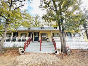 a yellow house with a white fence and trees at Acorn Hideaways Canton Delightful Christmas Suite Year Round in Canton