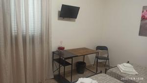 a room with a table and a television and a bed at VILLA VIOLA B & B in Baganzola