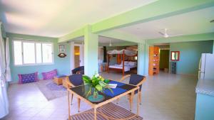 a dining room with a table and chairs and a living room at The Tree House Bella Seaview Diani Beach Kenya in Diani Beach