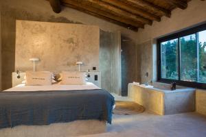 1 dormitorio con cama, bañera y ventana en Vigias -Eternal Landscapes, en Marvão