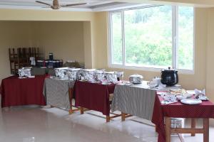 Zimmer mit 2 Tischen und roten Tischdecken in der Unterkunft White Coral in Port Blair