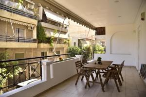 a balcony with a wooden table and chairs at Gtrip Piraeus Floor Apartment - 8324 in Piraeus