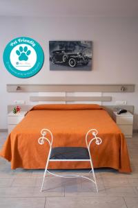 een bed met een oranje deken en een stoel in een kamer bij Apartamentos Comfort Calella in Calella