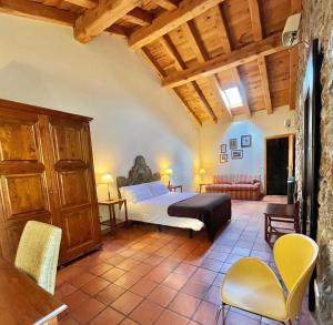 a bedroom with a bed and chairs in a room at Saltus Alvus, casas 4 estrellas con encanto en Sotosalbos in Sotosalbos
