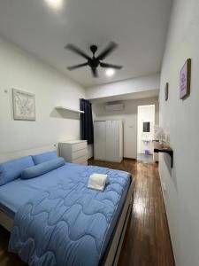 - une chambre avec un lit bleu et un ventilateur de plafond dans l'établissement Reizz Residence by AFFDECH, à Kuala Lumpur