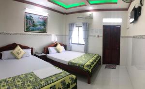 Habitación de hotel con 2 camas y TV en Nhà Nghỉ Việt Thắng en Bàu Dòi