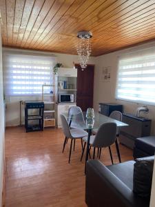 a living room with a table and chairs and a kitchen at Casa en entorno natural in Curicó