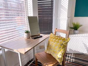a desk with a laptop and a chair in a room at Large House near MediaCity, sleeps 13 with FREE Parking and Fast WIFI - Contractor and Long Stay Friendly - by IRWELL STAYS in Manchester