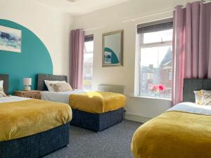 a room with two beds and a window at Large House near MediaCity, sleeps 13 with FREE Parking and Fast WIFI - Contractor and Long Stay Friendly - by IRWELL STAYS in Manchester