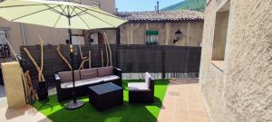 a patio with a bench and an umbrella at La Bombonera del Berguedà in Sant Jordi de Cercs