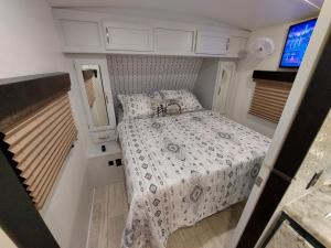 1 dormitorio con 1 cama en una habitación pequeña en The Torres' Camper Experience!, en Tampa
