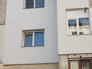 dos ventanas en el lateral de un edificio blanco en Cozy Studio Onesti, en Onești