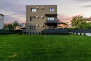 une grande maison avec une pelouse devant elle dans l'établissement Fit Residence, à Cluj-Napoca