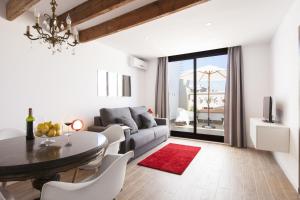 a white living room with a table and a couch at Charming Flats by Aspasios in Barcelona