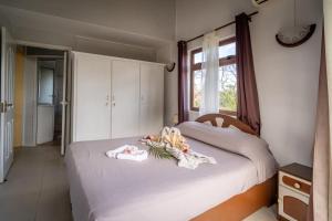 een slaapkamer met een bed met handdoeken erop bij Charming Condo in Rivière Noire