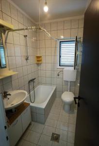 ein Badezimmer mit Badewanne, Toilette und Waschbecken in der Unterkunft Apartments Dijana in Rab
