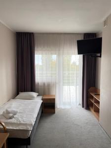 um quarto com uma cama e uma grande janela em Geovita w Jadwisinie em Jadwisin