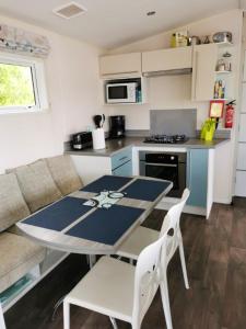 a small kitchen with a table and chairs in a caravan at Bungalow de 3 chambres avec piscine partagee jardin amenage et wifi a Onzain in Onzain