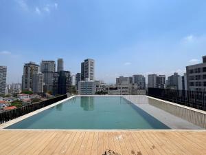 a swimming pool on the roof of a building with a city at Vossa bossa Vila Madalena in Sao Paulo
