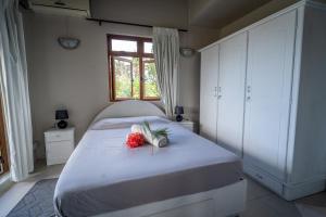 a bedroom with a white bed with flowers on it at Charming Condo in Rivière Noire