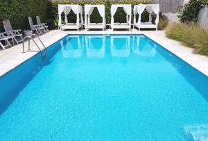 a swimming pool with chairs and a blue pool at Atlántico Boutique Hotel in Punta del Este