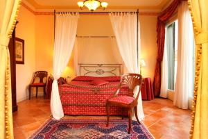 a bedroom with a bed and two chairs in it at Villa Fiorita in Monastier di Treviso