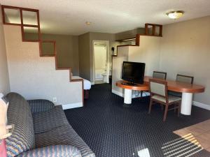 a living room with a desk and a tv and a staircase at Homegate Studio and Suites San Antonio in San Antonio