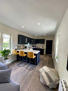 cocina abierta y sala de estar con sillas amarillas en Impeccable 1-Bed Apartment in gated secure setting, 