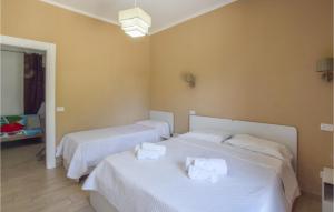- 2 lits dans une chambre avec des draps blancs dans l'établissement Nice Apartment In Gizzeria With Kitchen, à Gizzeria