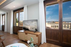 uma sala de estar com televisão e uma grande janela em SingularStays Ático Reina Catalina em Valência