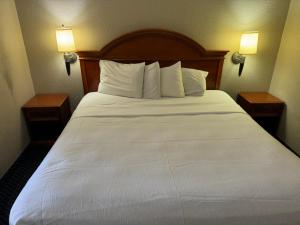 een groot wit bed in een hotelkamer met 2 lampen bij Homegate Studio and Suites San Antonio in San Antonio