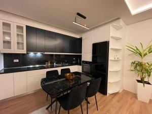 a kitchen with black and white cabinets and a table at Royal Seaview Apartment in Durrës