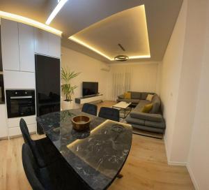 een keuken en een woonkamer met een tafel en een bank bij Royal Seaview Apartment in Durrës