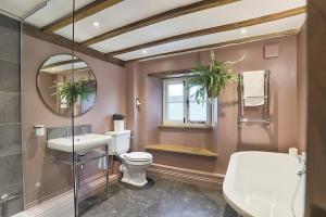 ein Badezimmer mit einem WC, einem Waschbecken und einem Spiegel in der Unterkunft Luxury Cotswold Cottage with hot tub in Stow on the Wold! in Stow on the Wold