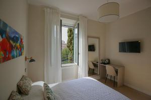 una camera con letto, scrivania e finestra di Colosseum Maison a Roma
