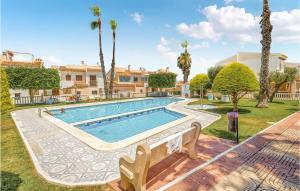 a swimming pool in a yard with palm trees at 2 Bedroom Beautiful Apartment In Rojales in Rojales