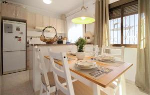 a kitchen with a table with white chairs around it at 2 Bedroom Beautiful Apartment In Rojales in Rojales