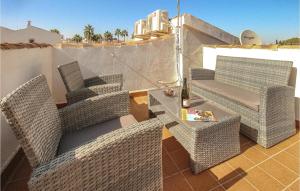 an outdoor patio with wicker chairs and a table at 2 Bedroom Stunning Apartment In Rojales in Rojales +12 photos