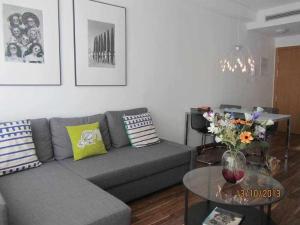 uma sala de estar com um sofá e uma mesa com flores em Apartamento Moderno with AirCo em Oliva