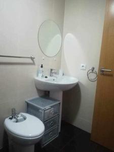uma casa de banho com um lavatório, um WC e um espelho. em Apartamento Moderno with AirCo em Oliva