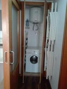 uma máquina de lavar e secar roupa num pequeno quarto em Apartamento Moderno with AirCo em Oliva