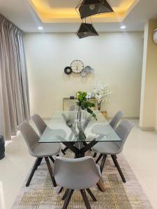 une salle à manger avec une table et des chaises en verre dans l'établissement Modern 2 bedroom apartment in Sakumono-Tema Beach Rd, Accra-Ghana, à Accra