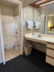a bathroom with a sink and a tub and a toilet at Homegate Studio and Suites San Antonio in San Antonio