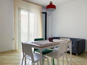 a dining room table with white chairs and a couch at Casa Velasquez in Palermo