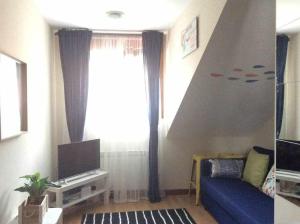 - un salon avec un canapé bleu et une fenêtre dans l'établissement Asturias Boho Chic, à Aller