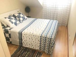 1 dormitorio con 1 cama con manta azul y blanca en Asturias Boho Chic en Aller
