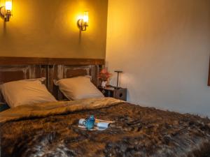 Una habitación de hotel con una cama con una bandeja encima. en Les Arts - Cocon romantique en Baie de Somme, en Boismont