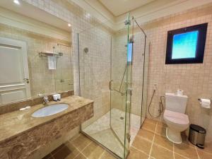 y baño con aseo, lavabo y ducha. en Loren Suites Corniche, en Yeda